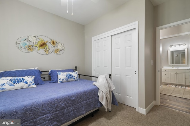 bedroom featuring a closet, hardwood / wood-style floors, connected bathroom, and ceiling fan