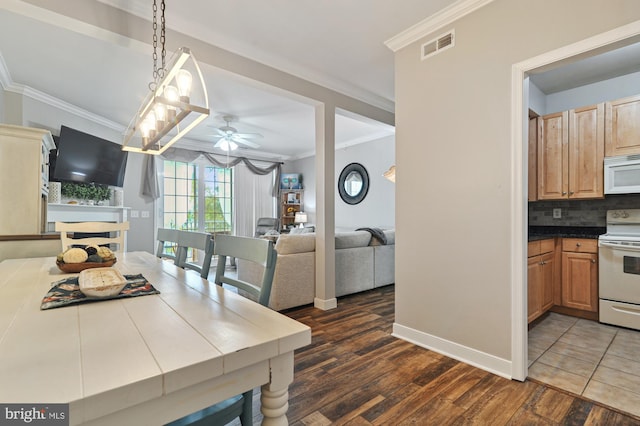 kitchen with white appliances, hanging light fixtures, ceiling fan, ornamental molding, and dark hardwood / wood-style floors