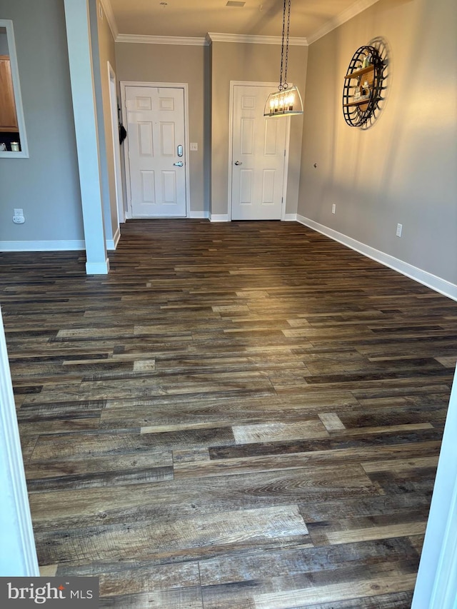 foyer entrance with ornamental molding and dark hardwood / wood-style flooring