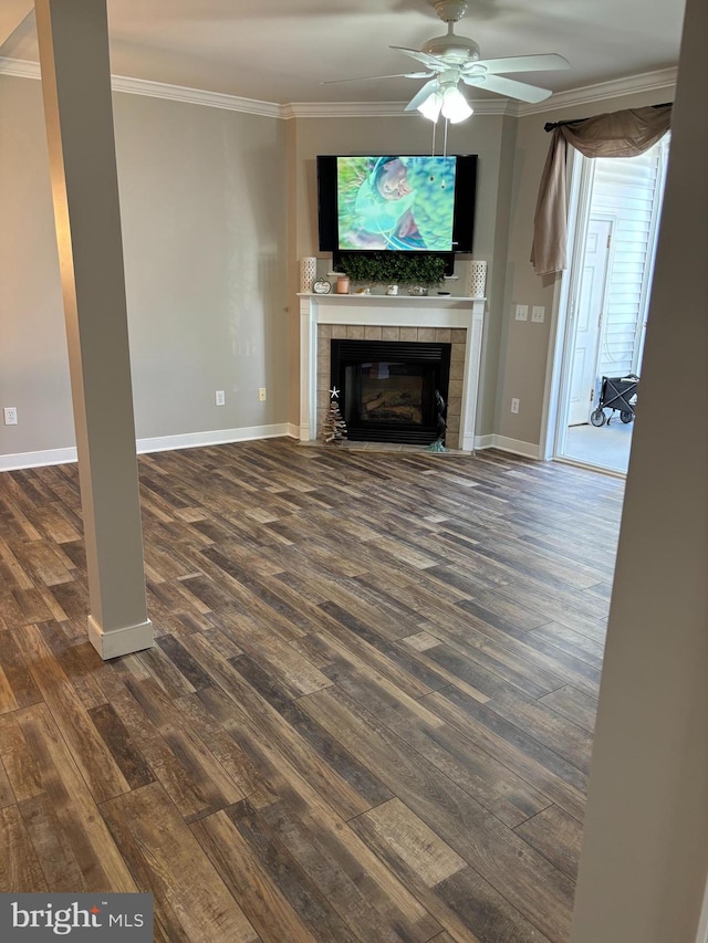 unfurnished living room with crown molding, a fireplace, dark hardwood / wood-style floors, and ceiling fan