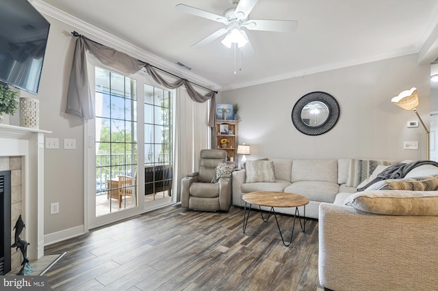 living room with ceiling fan, ornamental molding, dark hardwood / wood-style flooring, and a tile fireplace