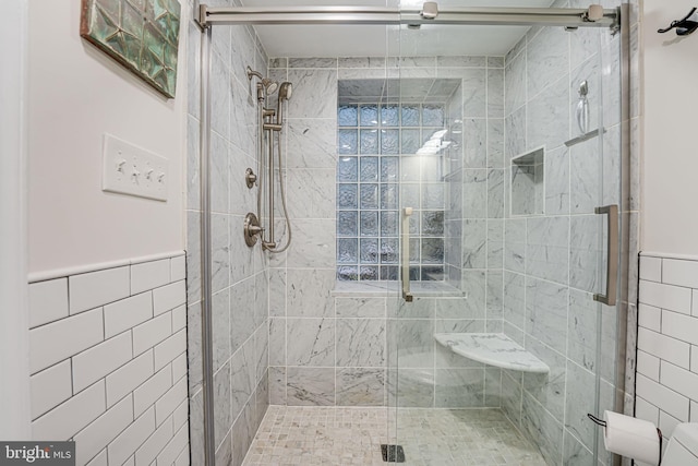 bathroom featuring tile walls and a shower with door