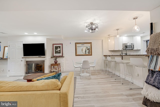 living room featuring sink and light hardwood / wood-style flooring