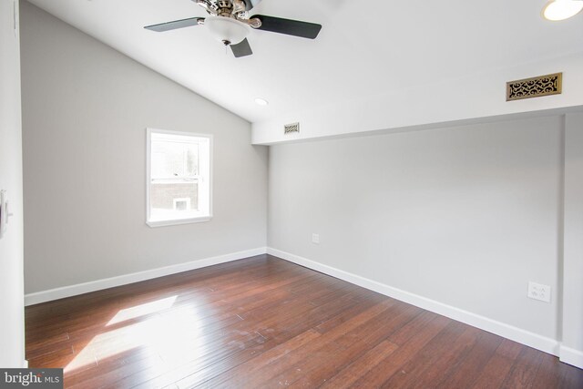 spare room featuring lofted ceiling, dark wood-type flooring, and ceiling fan