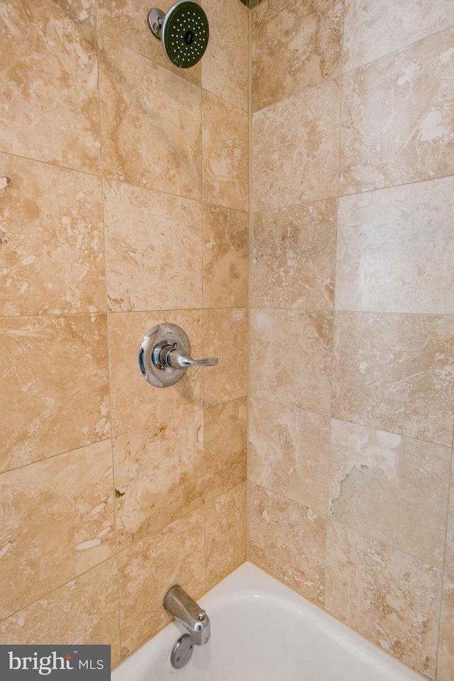 interior details featuring tiled shower / bath combo