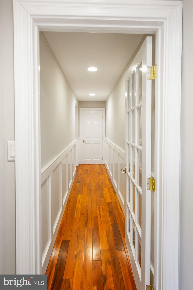 hallway with hardwood / wood-style flooring