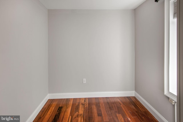 unfurnished room with dark wood-type flooring