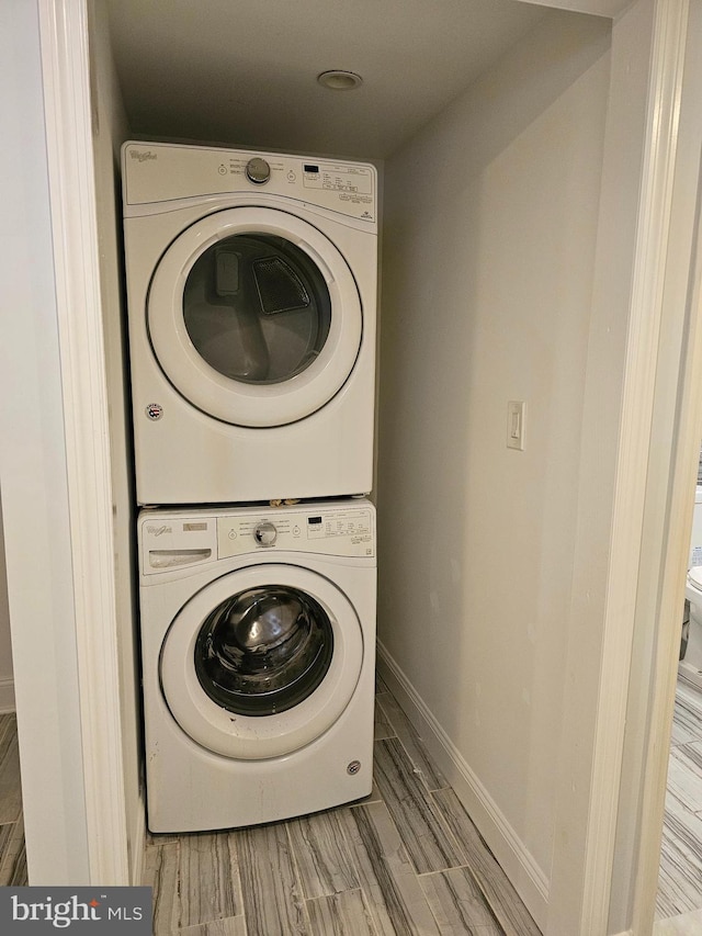 washroom featuring stacked washer / drying machine and light hardwood / wood-style floors