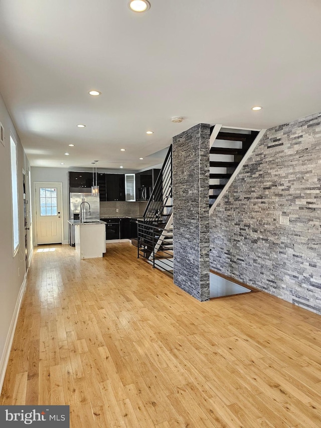 unfurnished living room featuring light hardwood / wood-style floors and sink