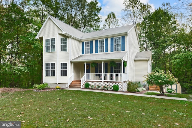 colonial inspired home featuring a front yard, a storage unit, and covered porch