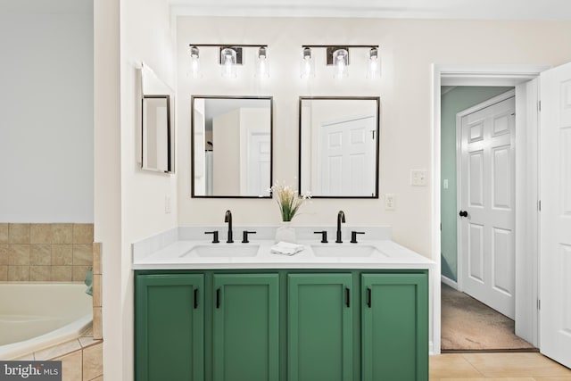 bathroom featuring tiled tub and vanity