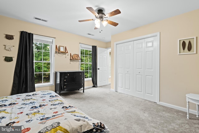 carpeted bedroom featuring ceiling fan and a closet