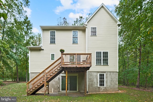 rear view of property featuring a lawn and a wooden deck