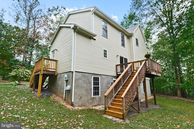 rear view of property featuring a deck and a yard