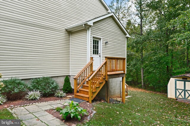 rear view of house with a storage unit and a lawn