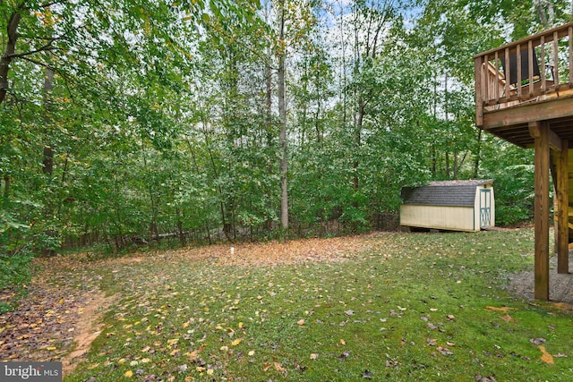 view of yard featuring a storage unit and a wooden deck