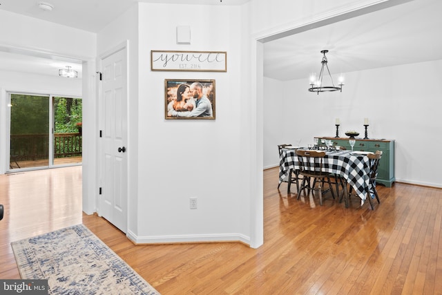 dining space featuring light hardwood / wood-style flooring and a chandelier