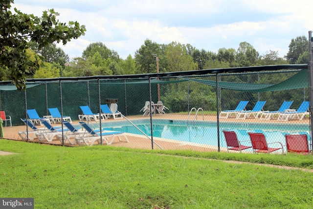 view of pool featuring a lawn