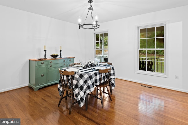 dining area with hardwood / wood-style flooring and a notable chandelier