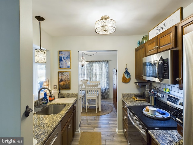 kitchen with an inviting chandelier, a healthy amount of sunlight, dark hardwood / wood-style floors, and stainless steel appliances