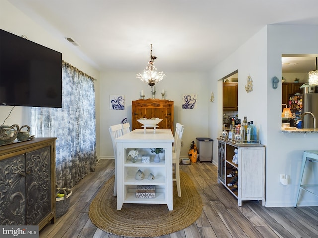 dining space with dark wood-type flooring and a chandelier