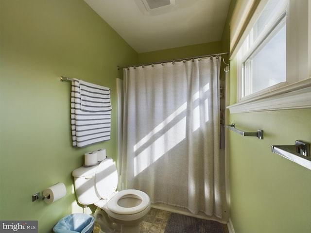 bathroom featuring toilet and a shower with shower curtain