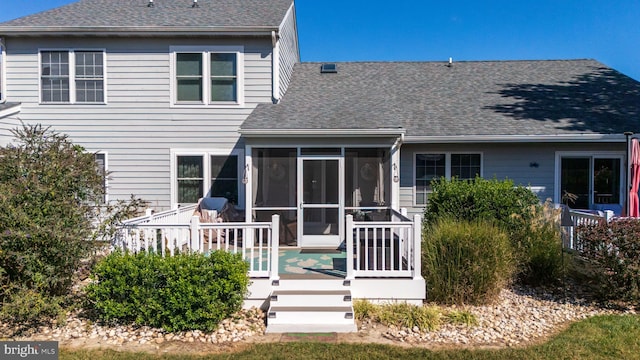 rear view of house featuring a deck and a sunroom