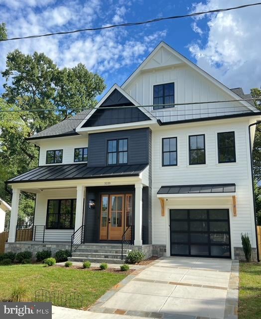 modern farmhouse style home featuring a front lawn, covered porch, and a garage