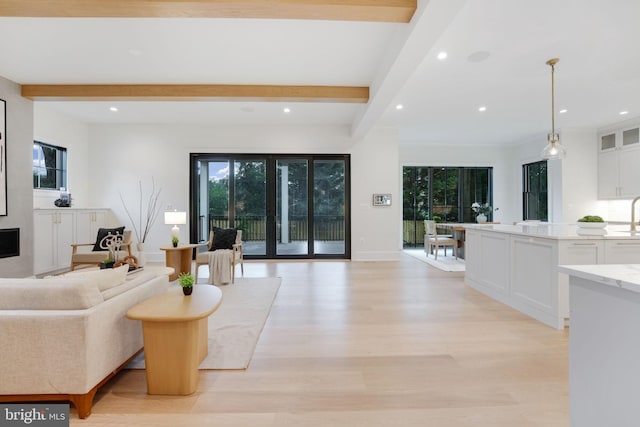 living room featuring light wood-type flooring and beam ceiling