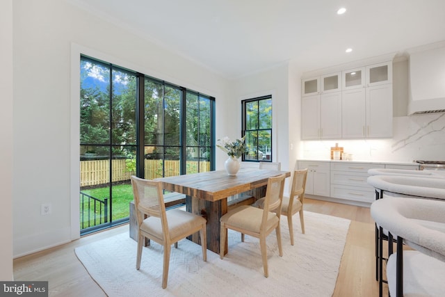 dining room featuring light hardwood / wood-style flooring and ornamental molding