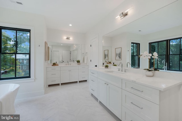 bathroom featuring a washtub and vanity