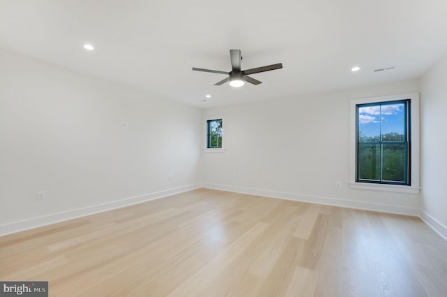 unfurnished room with light hardwood / wood-style flooring, ceiling fan, and a healthy amount of sunlight