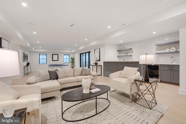 living room with light hardwood / wood-style flooring, indoor bar, and wine cooler