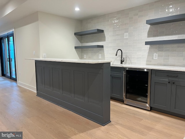 kitchen featuring light hardwood / wood-style flooring, decorative backsplash, wine cooler, and sink