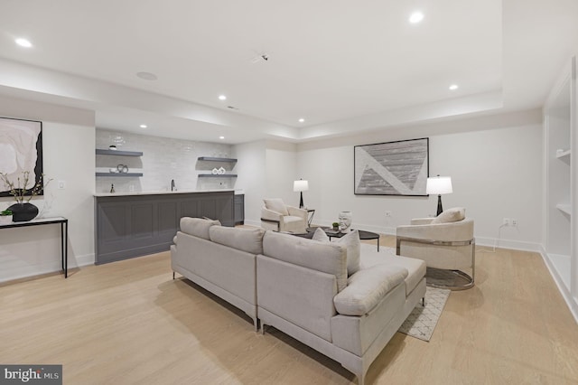 living room with light hardwood / wood-style floors and sink