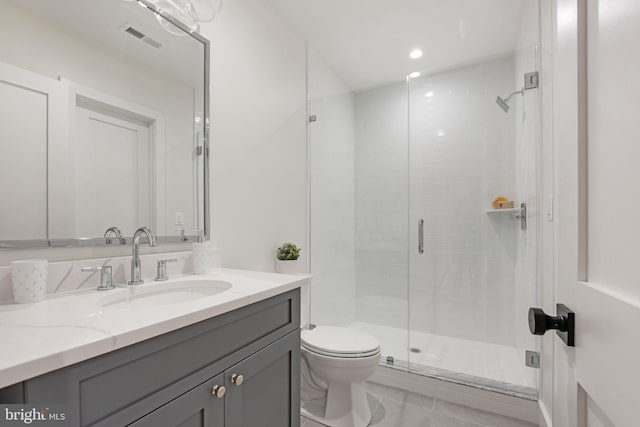 bathroom with tile patterned floors, a shower with shower door, vanity, and toilet