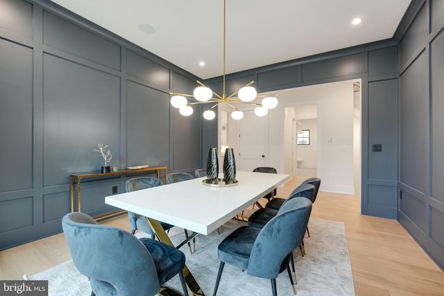 dining area with light hardwood / wood-style flooring and a chandelier