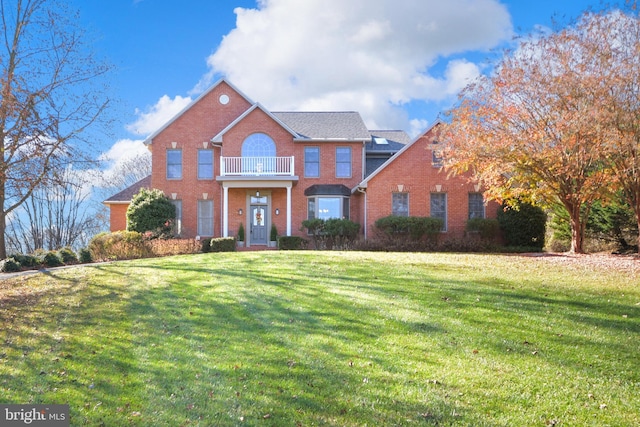 view of front of home with a front yard and a balcony