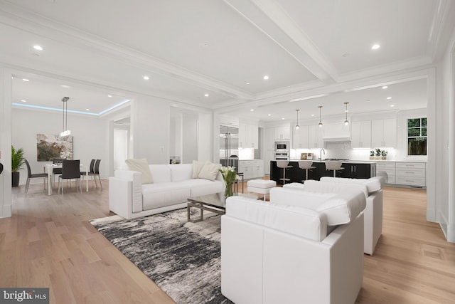 living room featuring light hardwood / wood-style flooring, beamed ceiling, and ornamental molding