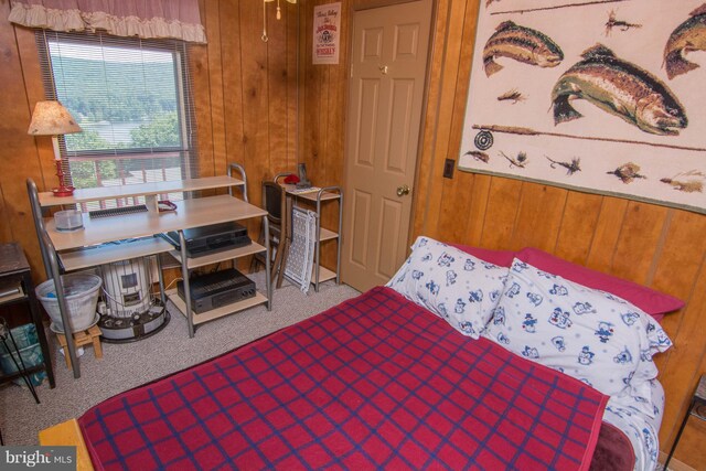 bedroom with carpet floors and wooden walls