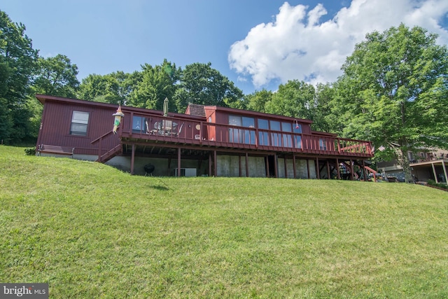 back of property featuring a wooden deck and a yard