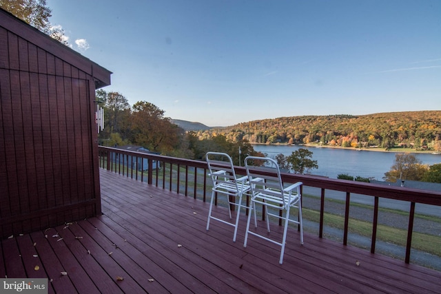 wooden terrace with a water and mountain view