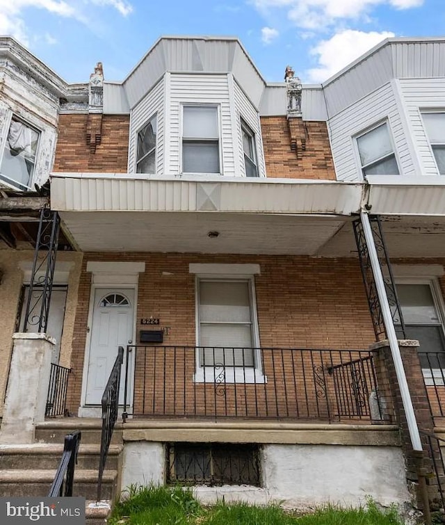 townhome / multi-family property featuring covered porch