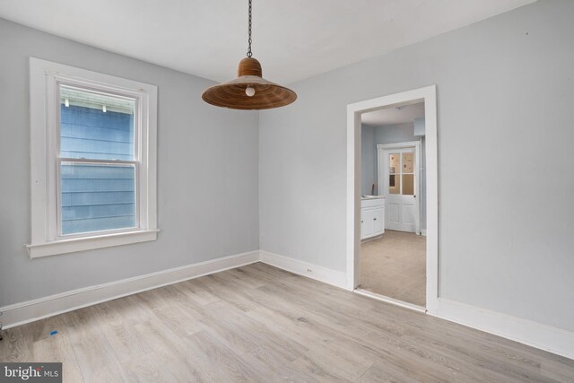 unfurnished dining area featuring light wood-type flooring