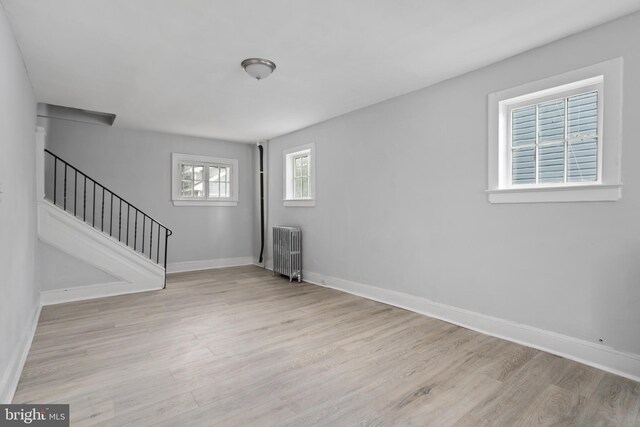 unfurnished living room with radiator and light hardwood / wood-style flooring