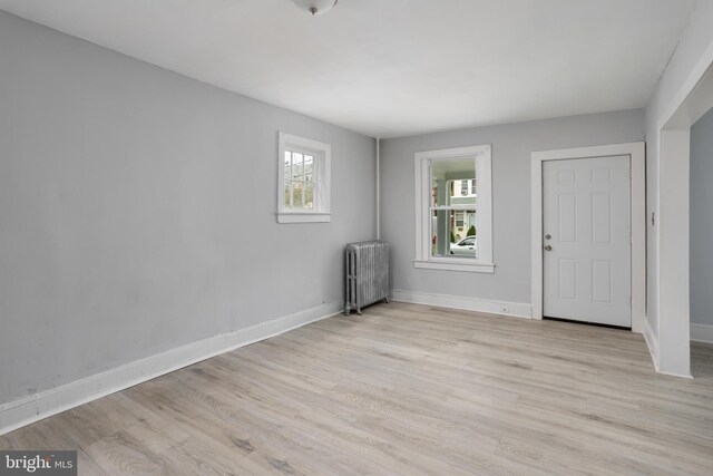 entryway with radiator heating unit and light hardwood / wood-style flooring