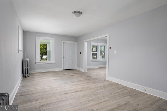 foyer entrance featuring light wood-type flooring and radiator heating unit