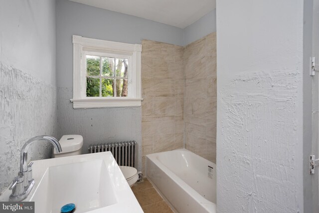 bathroom featuring tile patterned flooring, toilet, radiator, a tub, and sink