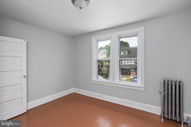 spare room featuring dark hardwood / wood-style floors and radiator heating unit