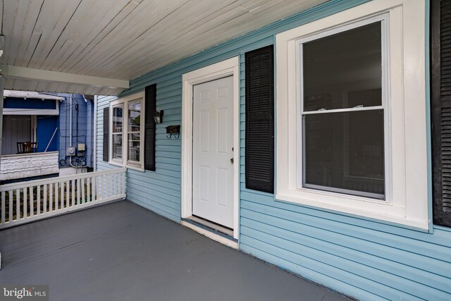 view of exterior entry featuring covered porch